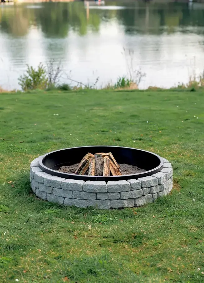 Custom brick fire pit on a lakeside lawn