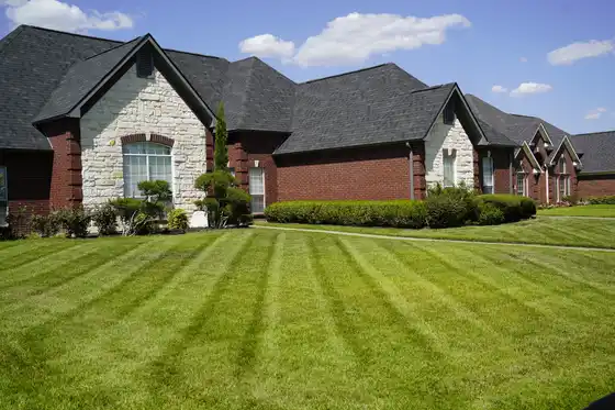 Striped lawn in front of a brick and stone home