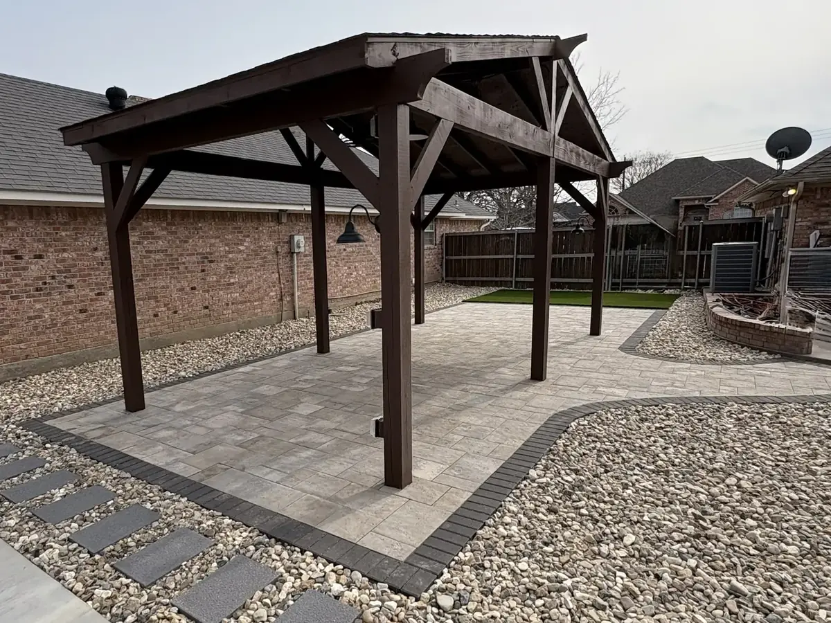 Cedar pergola over a paver patio with river rock and stepping stones